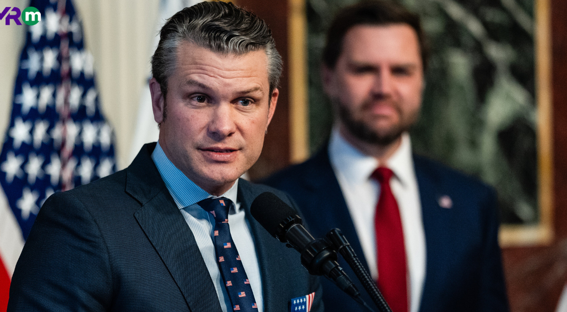 Pete Hegseth speaking at an event with an American flag in the background